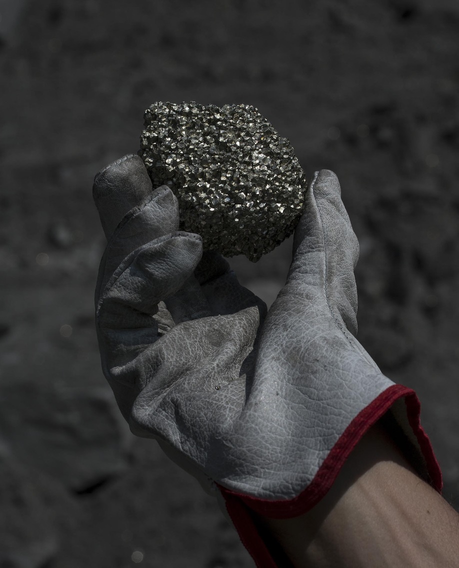 Photo: Gloved hand holding ore